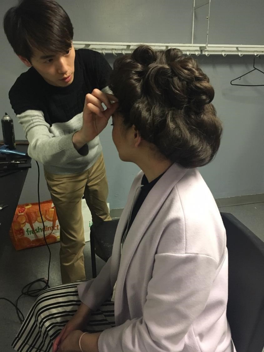 Seb adjusting Gibson girl style wig on actor.
