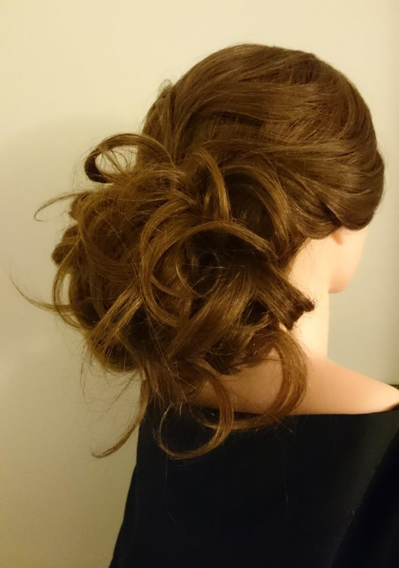 Low bun updo with wavy flyaways.